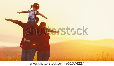 Photo of Happy family: mother father and child daughter on nature  on sunset