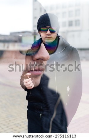 You can see a building down town through the portrait of a man with glasses. Double exposure. portrait of man