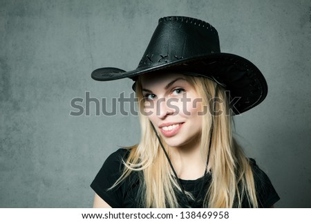 Woman with cowboy hat on gray background