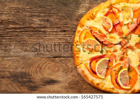 Salmone pizza on old wooden table. Top view with place for text.
