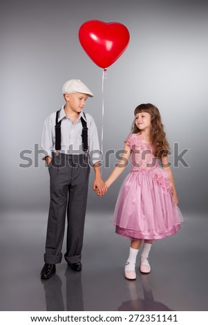 Cute children walk with a red balloon. Photo in retro style.