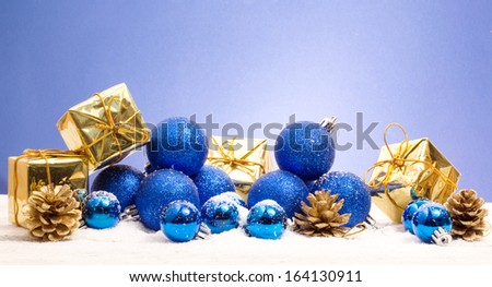 blue and gold christmas decorations over snow