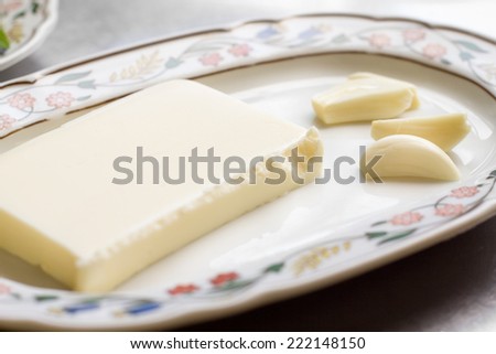 butter and clove of garlic over painted plate