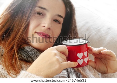 long hair girl with Valentine decorated mug over sofa