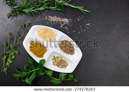 aromatic herbs and dried spices over slate sheet