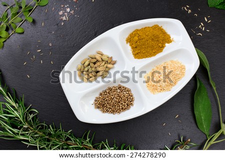 aromatic herbs and dried spices over slate sheet