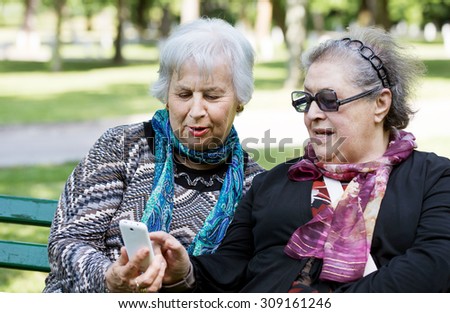 two senior ladies discovering technology with smart phone
