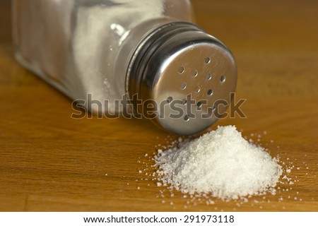 Salt spilling on table from salt cellar