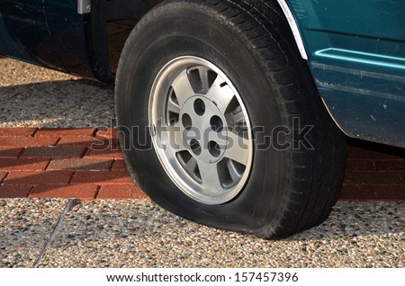 vehicle on city street with flat tire