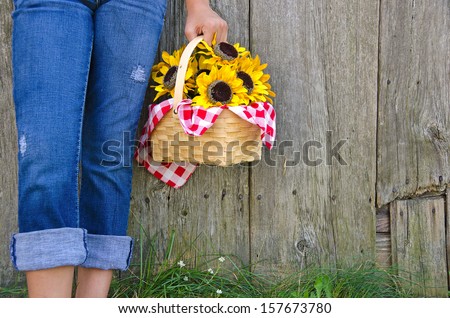 country girl with sunflower basket by old barn