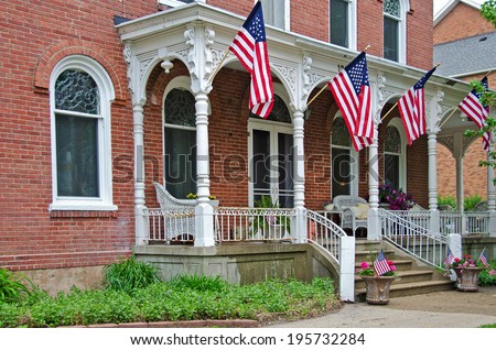 French Italianate mansion with American flags on veranda