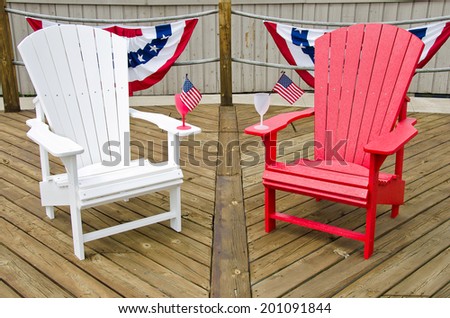 red and white Adirondack chairs on wooden deck with flag bunting
