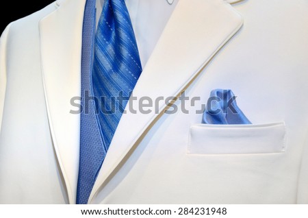 blue satin tie, vest and handkerchief in pocket accenting a white tuxedo