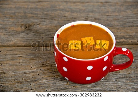 tomato soup in a red soup mug with white polka dots on rustic wood