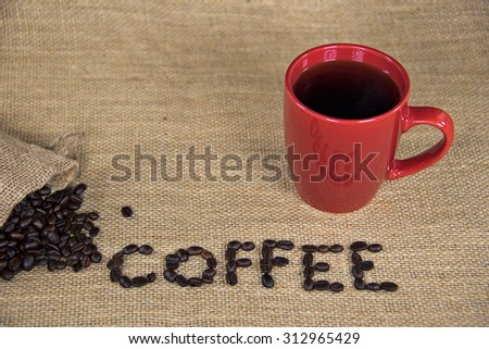 raw coffee beans and sack on burlap with red coffee mug
