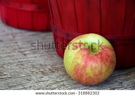 apple and red bushel basket on weathered wood at the market