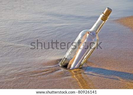 message in a bottle stuck in sand