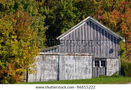 weathered barn in fall foliage