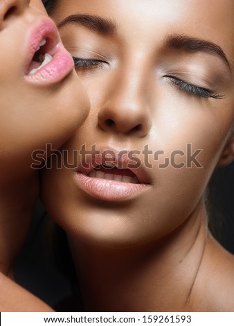 Emotive portrait of two gorgeous girlfriends. Perfect skin. Close up. Studio shot