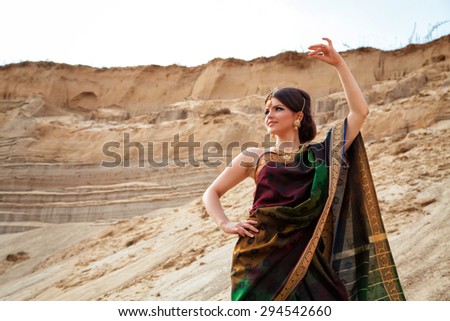Young woman in traditional indian dress against the sand background