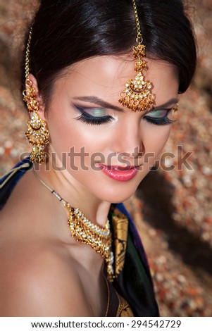 Beautiful girl with oriental make-up, indian sari and indian jewelry