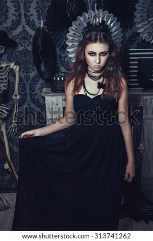 Brunette young girl in the image of queen with crown - Halloween style