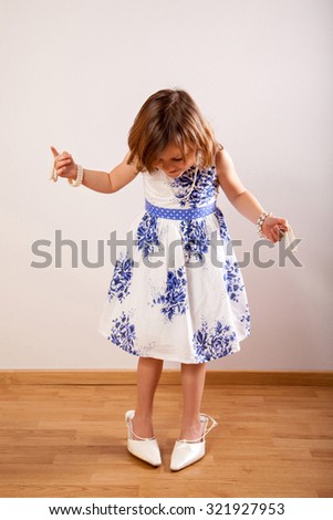 Little cute girl with her mother\'s jewelry and in her mother\'s shoes