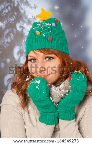 Portrait of woman in winter with snow and hat and gloves of Christmas tree