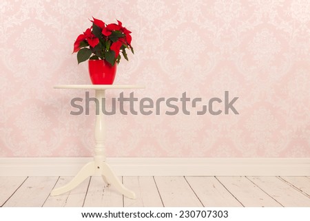 Vintage table in interior with Poinsettia and old wall paper
