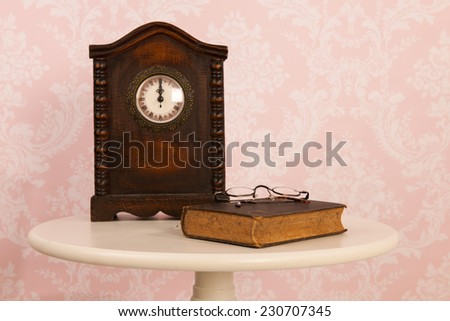Vintage table in interior with old wall paper and clock