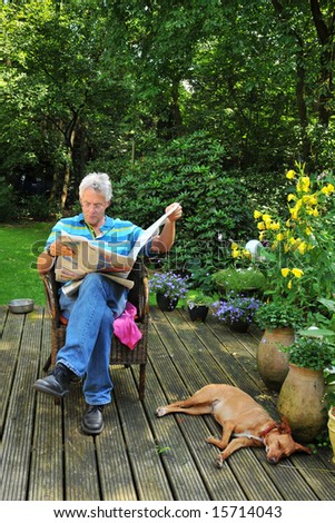 Senior man is reading newspaper outdoor