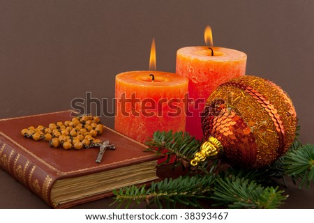 christmas candle and bible with rosary on brown