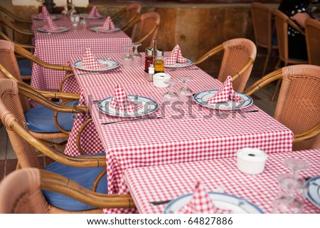 restaurant with rattan with checked table cloths at the terrace