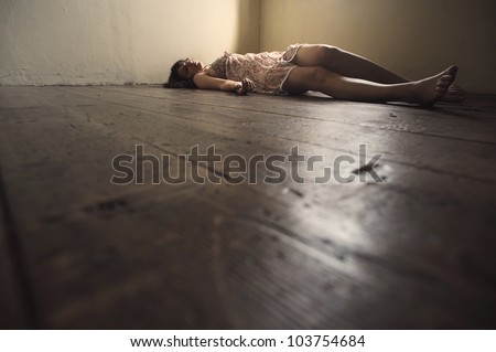 Dead woman lying on the wooden floor. Empty room
