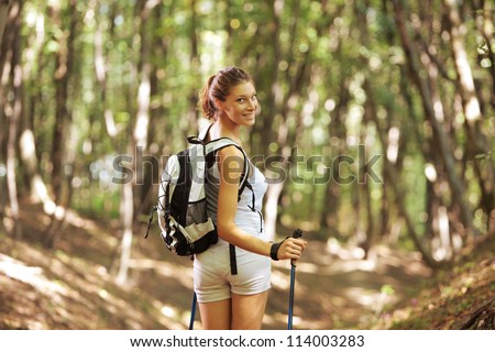 Young woman with walking sticks in a forest