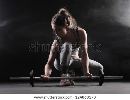 Body building: young woman lifting weights