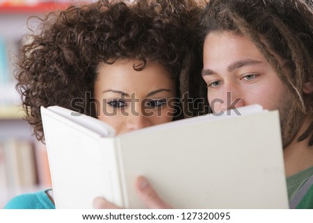 Two students reading a book together
