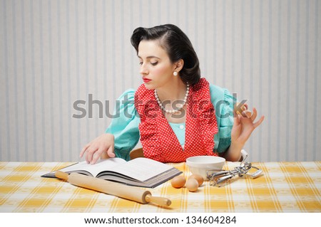 Young woman looking at a Recipe for a cake