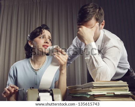Stressed man and woman looking at their bills in the living-room at home