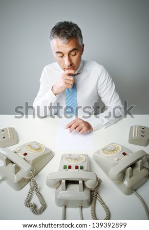 Mature business man with three phone waiting for a call