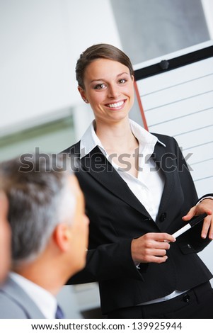 Portrait of a smiling businesswoman giving a presentation at work