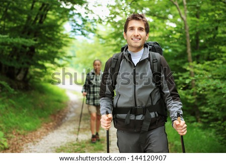 Young couple enjoying a nordic walk, man is smiling