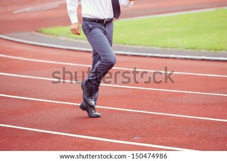A businessman is running in the sports track