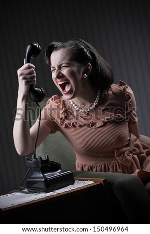 Angry woman screaming at retro phone, 1950 style
