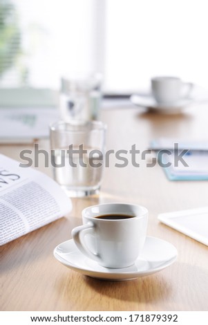 Business Office scene, Coffee, newspaper, water glass on meeting desk