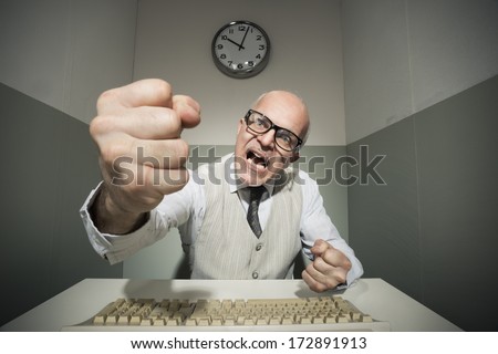 Vintage office worker angry and yelling at computer.