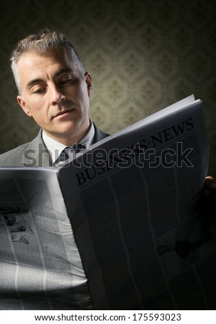 Handsome businessman reading news against vintage wallpaper background.