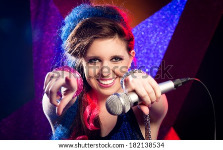 Young attractive singer on stage smiling at camera.