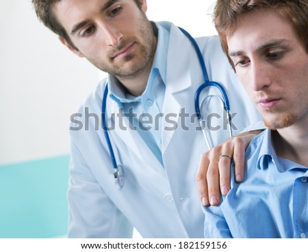 Doctor comforting a young patient after telling him bad news.