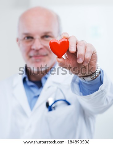 Doctor holding an heart, cardiologist and cardiovascular diseases concept.